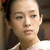 Static pixelated image of a person with light skin tone, dark hair tied back, wearing white clothing and visible necklace.