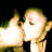 Two pixelated figures with light skin tones and short hair pose closely together against a black background, one figure's hand raised in a gesture.