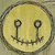 A circular yellow icon with a dark brown border features two anchor symbols forming a smiley face on a pixelated background.