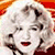 Two side-by-side animated frames of a pixelated cartoon character with curly blonde hair and red lips against an orange-red gradient background.