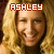 A pixelated image of a smiling person with long blonde hair, featuring the name 'ASHLEY' in blocky text above their head.