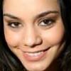 A close-up of a person's face with dark hair, showing eyes, nose, mouth, and part of the forehead against a dark background.