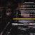 A static pixelated image shows a dark background with layered horizontal elements including gold, white, and pink bands.