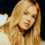 Static pixelated image of a person with long blonde hair wearing a dark choker necklace against a dark background.