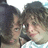 Two people with brown hair in a close-up pose, one person's head slightly turned left while the other remains forward-facing.