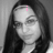 A black-and-white photo of a person with long dark hair and glasses, with pink pixelated text overlays in different positions across four