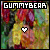 Pixelated image with 'GUMMYBEAR' text at top, colorful abstract background, and a white heart symbol centered below the text.