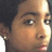 Pixelated close-up of a person's face with light skin tone, dark hair visible on the left side, and neutral expression.