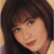 Pixelated close-up of a person with dark brown hair and light skin, wearing a dark top against a gradient background.