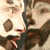 Pixelated image of a person with light skin and brown hair, wearing dark clothing, holding an object near their mouth.