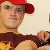 Pixelated static image of a person wearing a red cap and brown jacket, holding a small object near their face.