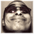 20 pixelated faces with changing red-tinted glasses, each face showing a slight smile and neutral expression against a sepia-toned background