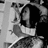 Pixelated grayscale image of a person with dark hair and light clothing, partially cropped on the right side.
