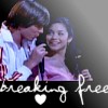 Two people in close proximity, one holding a microphone, with stylized text and a heart symbol below.