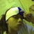 A person with long dark hair wears a white headband with blue accents, positioned against a light green background.