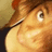Pixelated close-up of a character with light brown hair, large eye, and visible nose against warm-toned background.