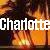Pixelated image with bold white text 'Charlotte' overlaid on a warm-toned, blurred background of orange and brown hues.