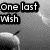 Pixelated grayscale image with bold text reading "One last wish" over a blurred background featuring partial shapes.