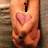 A pixelated image of a person's torso with hands clasped over a heart-shaped symbol, displaying text changes across frames.
