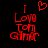 Red pixelated text 'I Love Tom Gilmour' with a heart symbol above the word 'Love', displayed on black background.