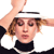 Pixelated image of a person with light brown hair wearing a white headband and black top, raising one arm above their head against a white background.
