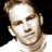 Static 48x48 pixel icon of a person's face with brown hair and light skin tone, rendered in low-resolution grayscale tones on black background.