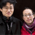 Two pixelated figures stand side-by-side against a dark background; the left figure wears a black jacket with a zipper, the right figure wears a red top with a purple scarf.