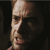 Pixelated close-up of a person's face showing a nose, eye, and mouth against a dark background.
