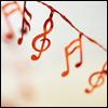 Static icon featuring red musical notes and a treble clef on a light background with subtle blur effects.