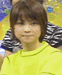 A person in a bright yellow shirt with short brown hair appears in a of showing subtle facial expression changes