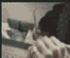 A sequence of showing a person in dark clothing performing actions with raised arms and head movements against an indistinct background
