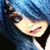 Pixelated close-up of a smiling face with light skin, dark hair, and blue background, rendered in low-resolution digital style.