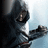 Pixelated figure in dark hooded attire with outstretched arm against light blue background, showing partial face and hand details.