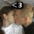 A pixelated image of two people kissing, with a heart symbol and text overlays.