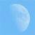 A pixelated crescent moon shape in light blue and white against a solid light blue background, rendered with low-resolution blocky pixels.