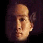 repeated human faces with varying expressions and angles against a dark background