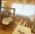 Pixelated static image showing a room interior with wooden furniture and a window with light streaming through.