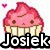 Pixelated cupcake icon with pink frosting, two brown eyes, and a small mouth, surrounded by small purple hearts on a white background.