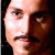 Pixelated close-up of a person's face showing eye, nose, and mouth with dark hair against dark background