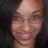 Pixelated close-up of a person's face with closed eyes and a slight smile, set against a dark background.