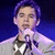 Pixelated image of a person with purple hair holding a microphone against dark blue background, next to cyan with pink and green text