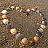 A 48x48 pixel animated buddy icon featuring a circular arrangement of seashells on sandy background with green text logo on the right side.