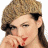 A pixelated image of a person with light brown hair styled in an updo, wearing red lipstick and holding hands near the mouth against a white background.
