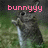 Pixelated image with pink text 'bunnyyy' above a dark figure holding a light-colored object against green and gray background.