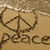 A pixelated icon featuring a peace symbol inside a heart outline with the word 'Peace' below, set against a textured beige background.