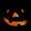 A pumpkin face with triangular eyes and nose, glowing orange mouth, and black background, showing animation changes across frames.