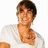 Pixelated image of a person with short dark hair wearing a white shirt, smiling against a plain background.