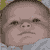 Two identical pixelated baby faces with downturned mouths, brown hair, and light blue clothing against a green and gray background.