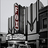 Pixelated grayscale image of a building facade with vertical architectural elements and a red vertical stripe on the left side.