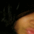 A pixelated close-up of a person's face with closed eyes, partially obscured by dark hair against a black background.